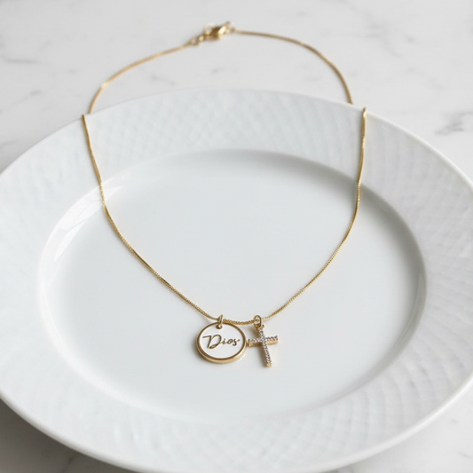 Gold necklace with a pendant on a white plate