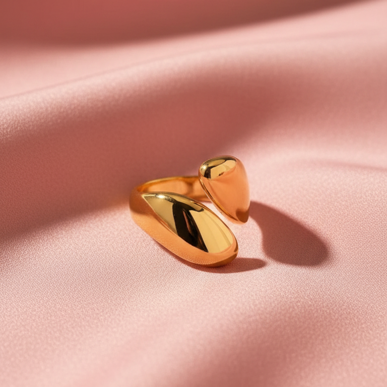 Gold Droplet ring on a pink fabric background