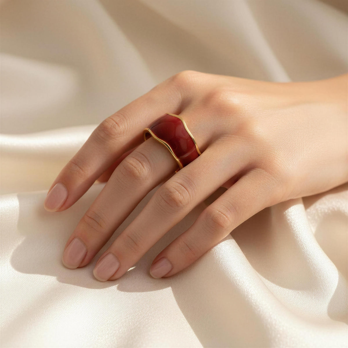 Model hand wearing the The Duna Ring – Carmine
From Chica Chica Jewelry against silk crème fabric.