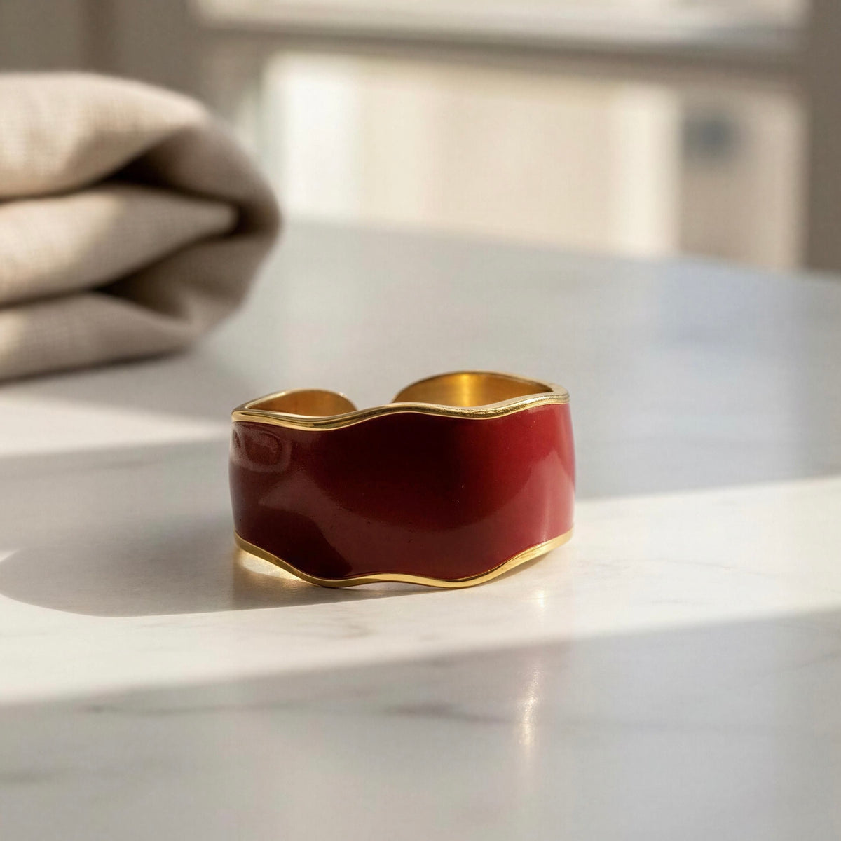 The Duna Ring – Carmine from Chica Chica Jewelry against a marble table by window.