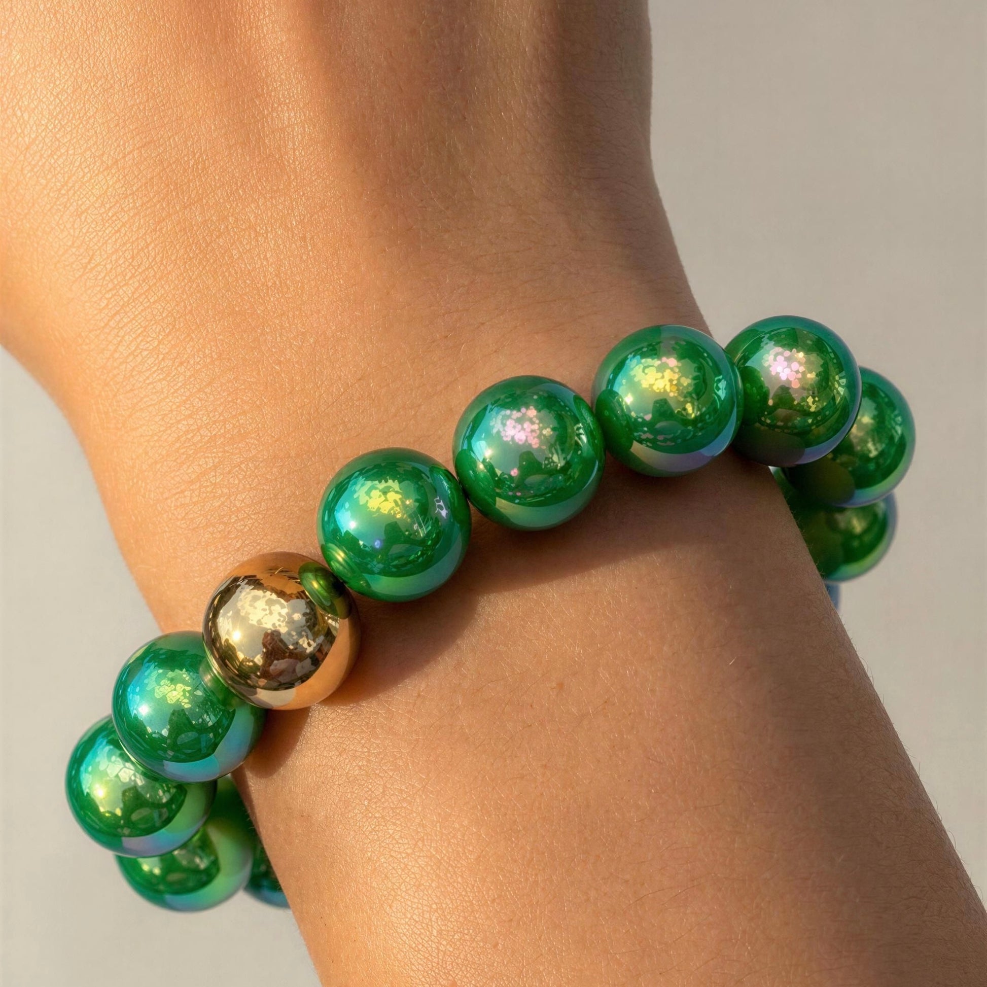 The Emerald Glow Bracelet with a gold accent on a wrist against a neutral background