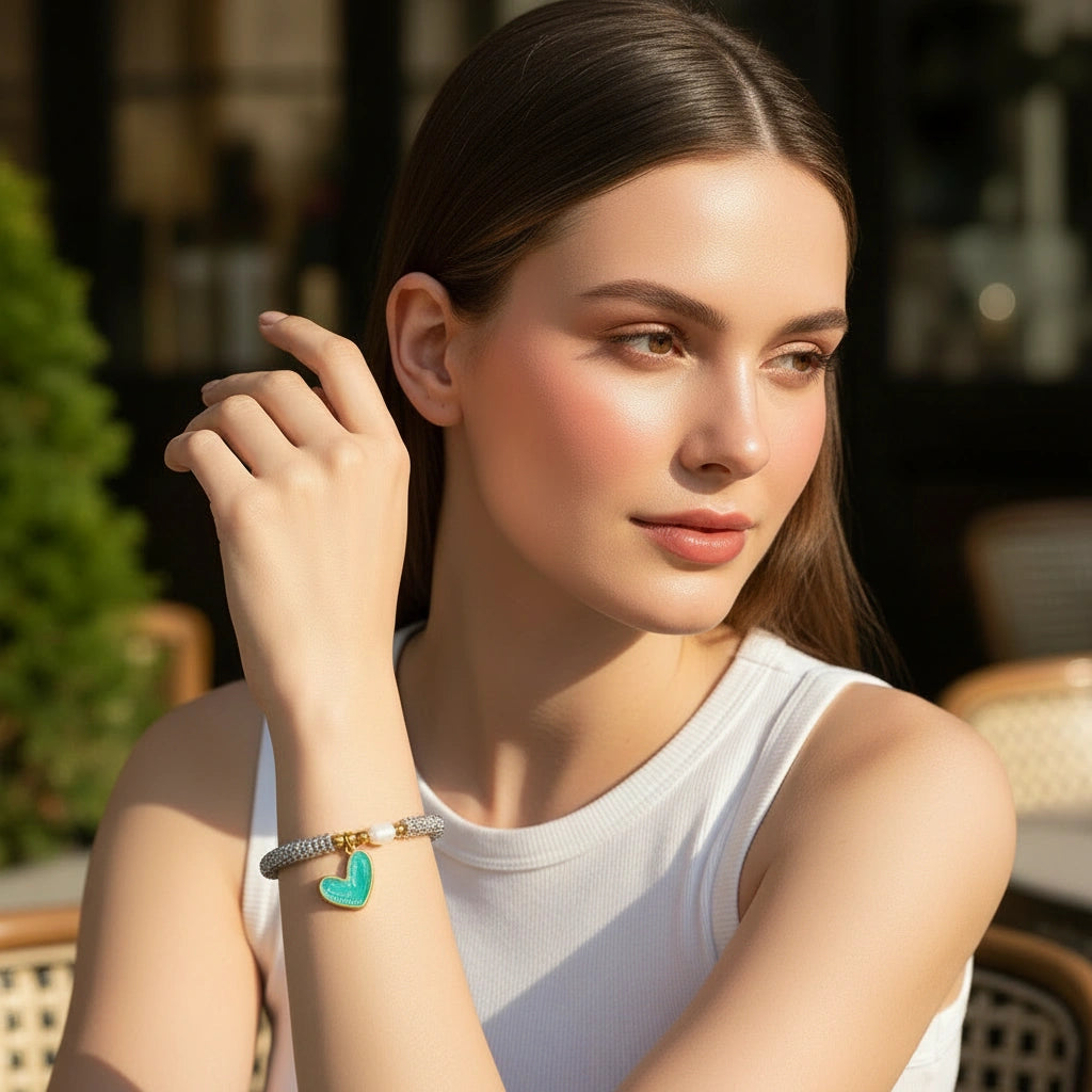 Model at outdoor cafe wearing the Endless Promise Mint Heart Bracelet
