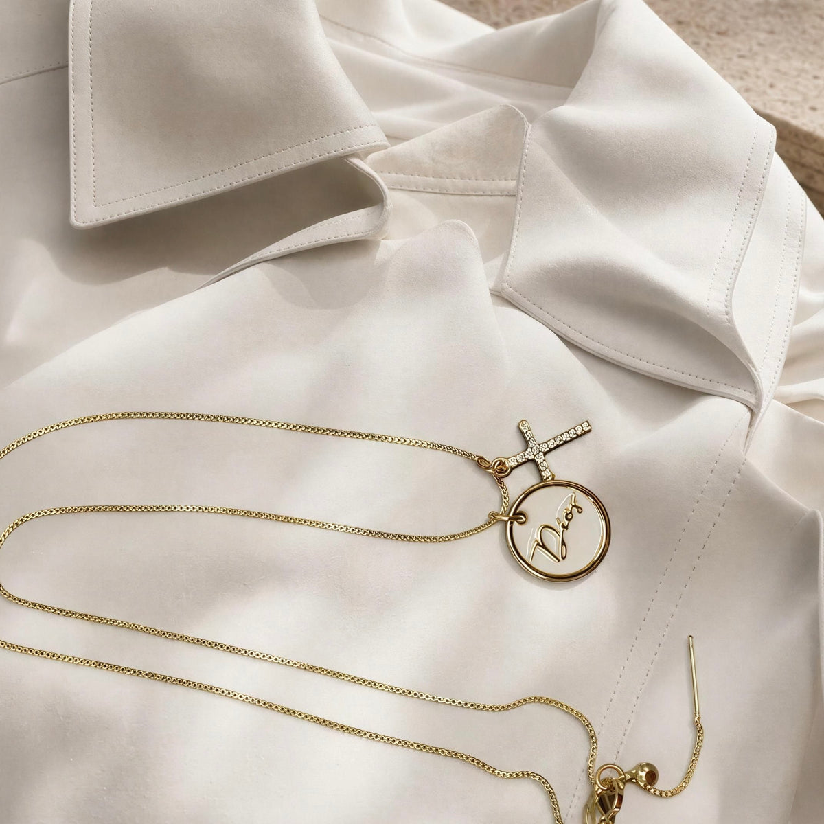 The Grazia Necklace- from Chica Chica Jewelry against a white trench coat.