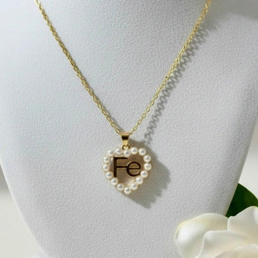 Chica Chica Jewelry - Gold necklace with a heart-shaped pendant on a white bust, accompanied by a white gardenia.