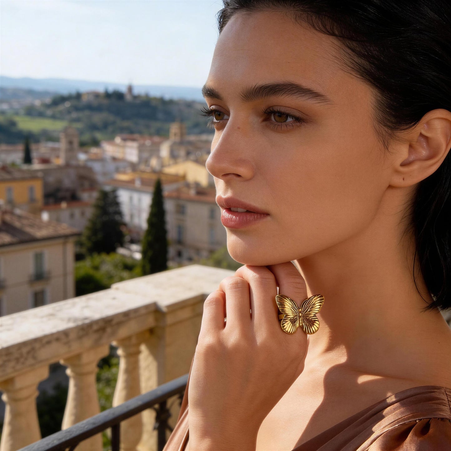 Woman wearing the  Forever Flutter Ring - Gold  with a scenic city view in the background