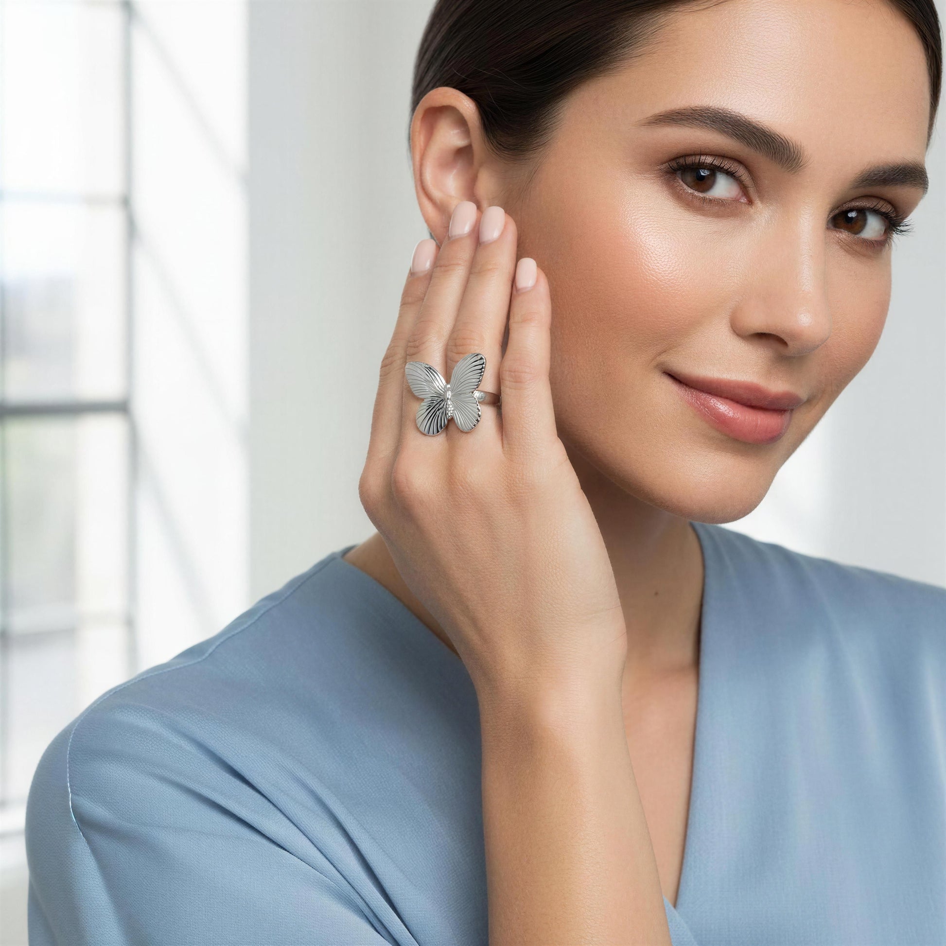 Woman wearing a butterfly-shaped ring with a blurred background