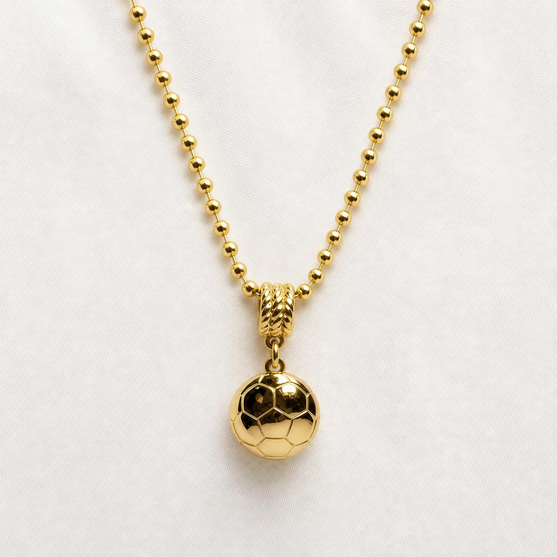 Gold necklace with a gold soccer ball pendant on a white background