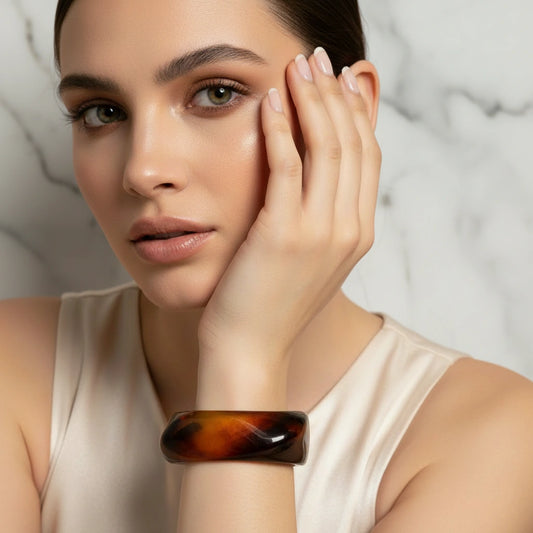Woman wearing the Golden Ember Bangle against a neutral background