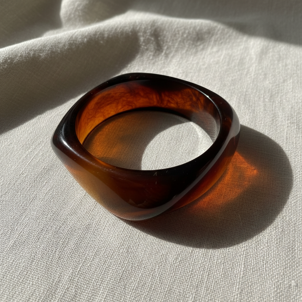Golden Ember Bangle on a light fabric background
