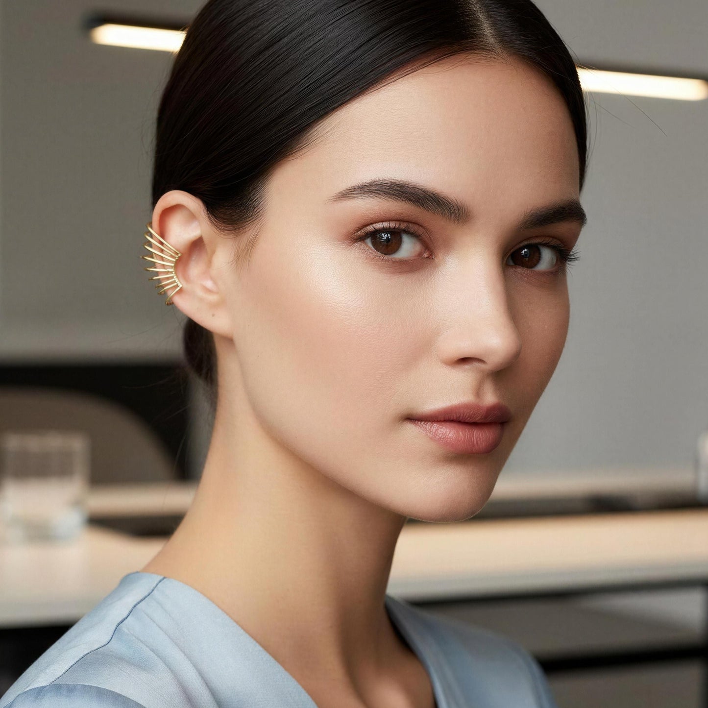 Woman wearing the Golden Horizon Ear Cuff in an office setting