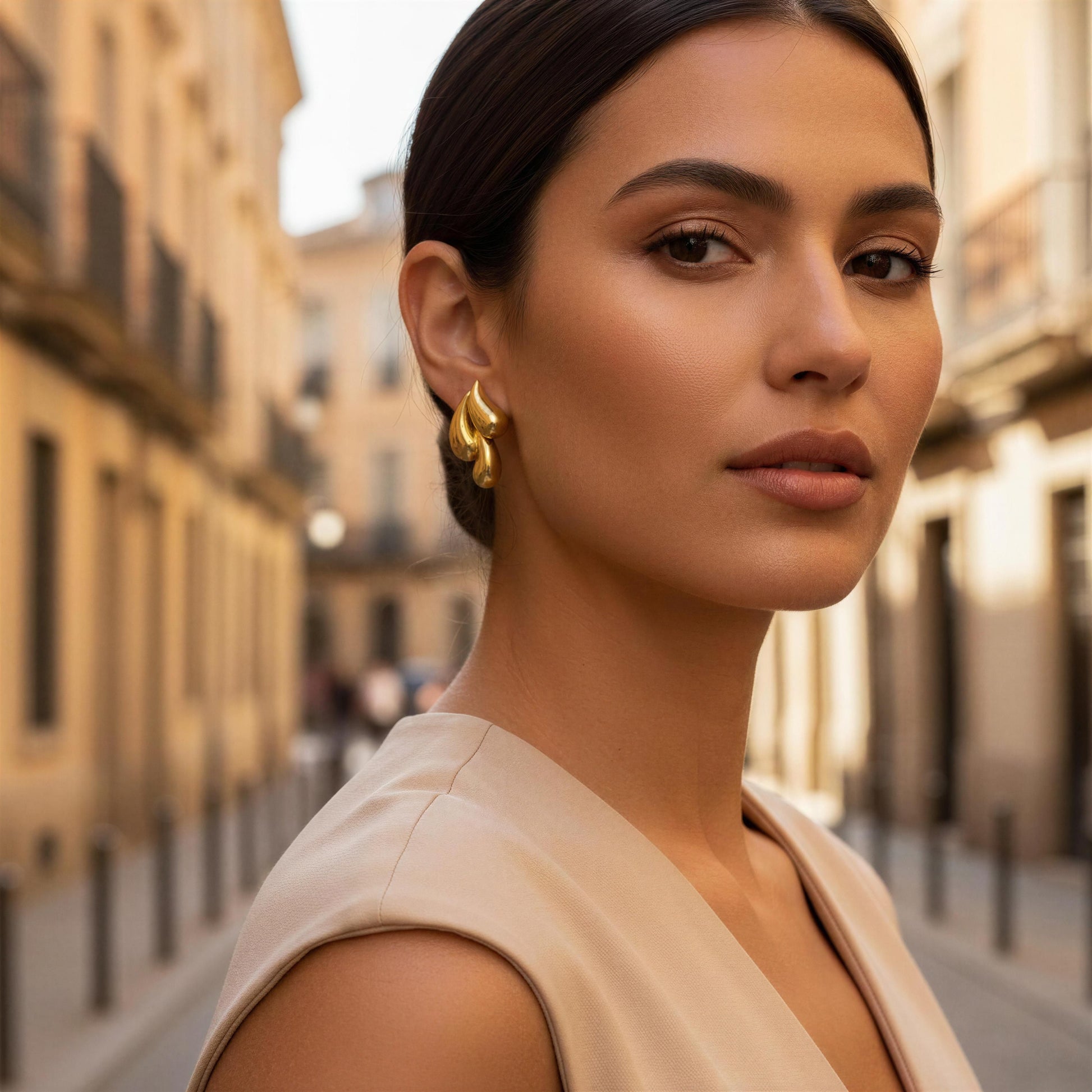 Woman with gold earrings standing on a city street