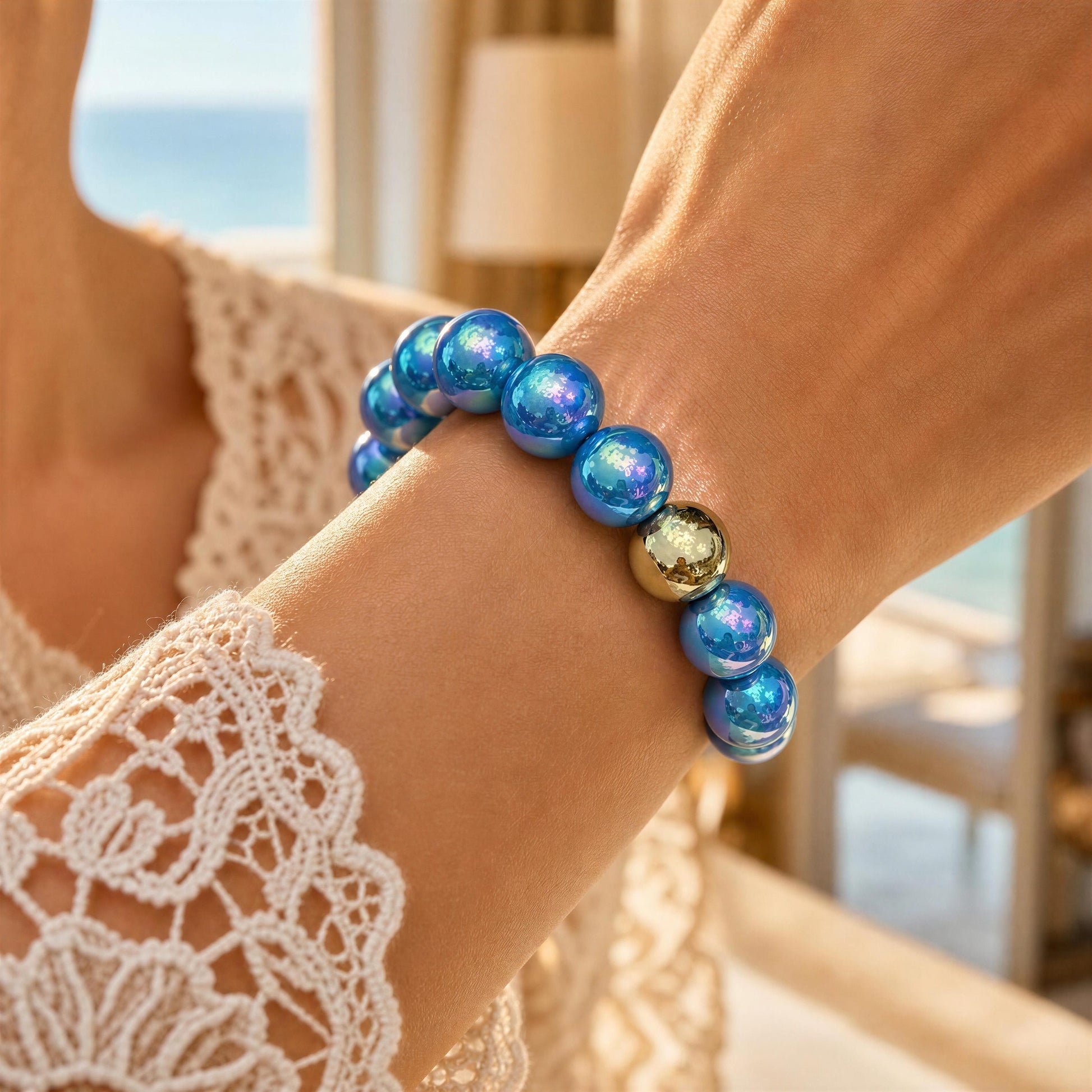 Close-up of a wrist wearing a blue beaded bracelet with a gold accent, against a blurred indoor background.