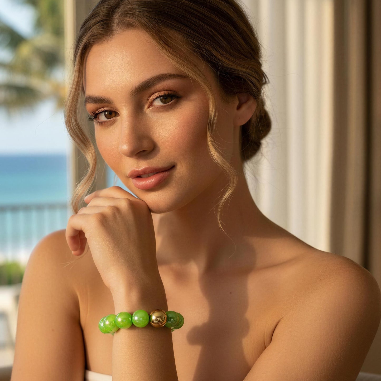 Woman wearing a green beaded bracelet with a blurred beach background