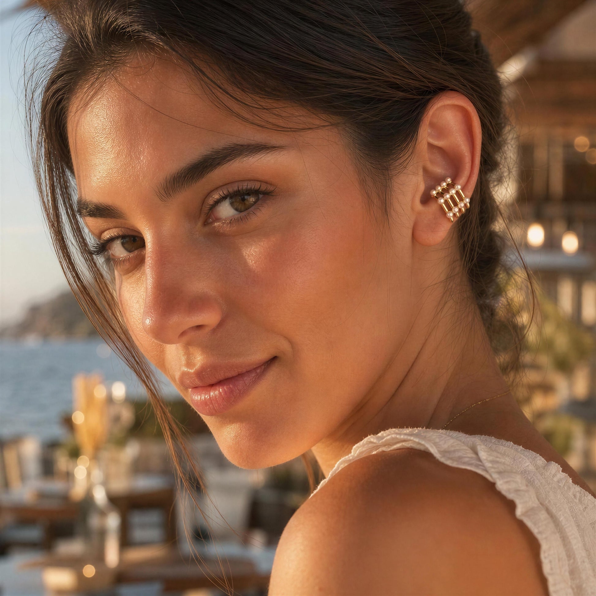 Woman wearing the Grid Pearl Ear Cuff featuring pearl accents and 18K gold-plated architectural detailing