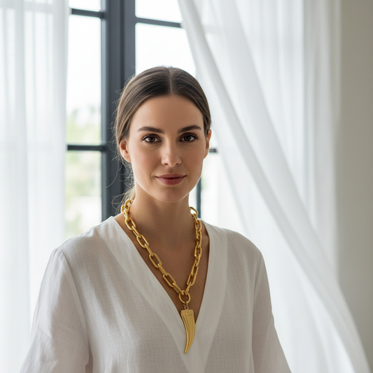 Woman wearing a gold necklace in a bright room with white curtains
