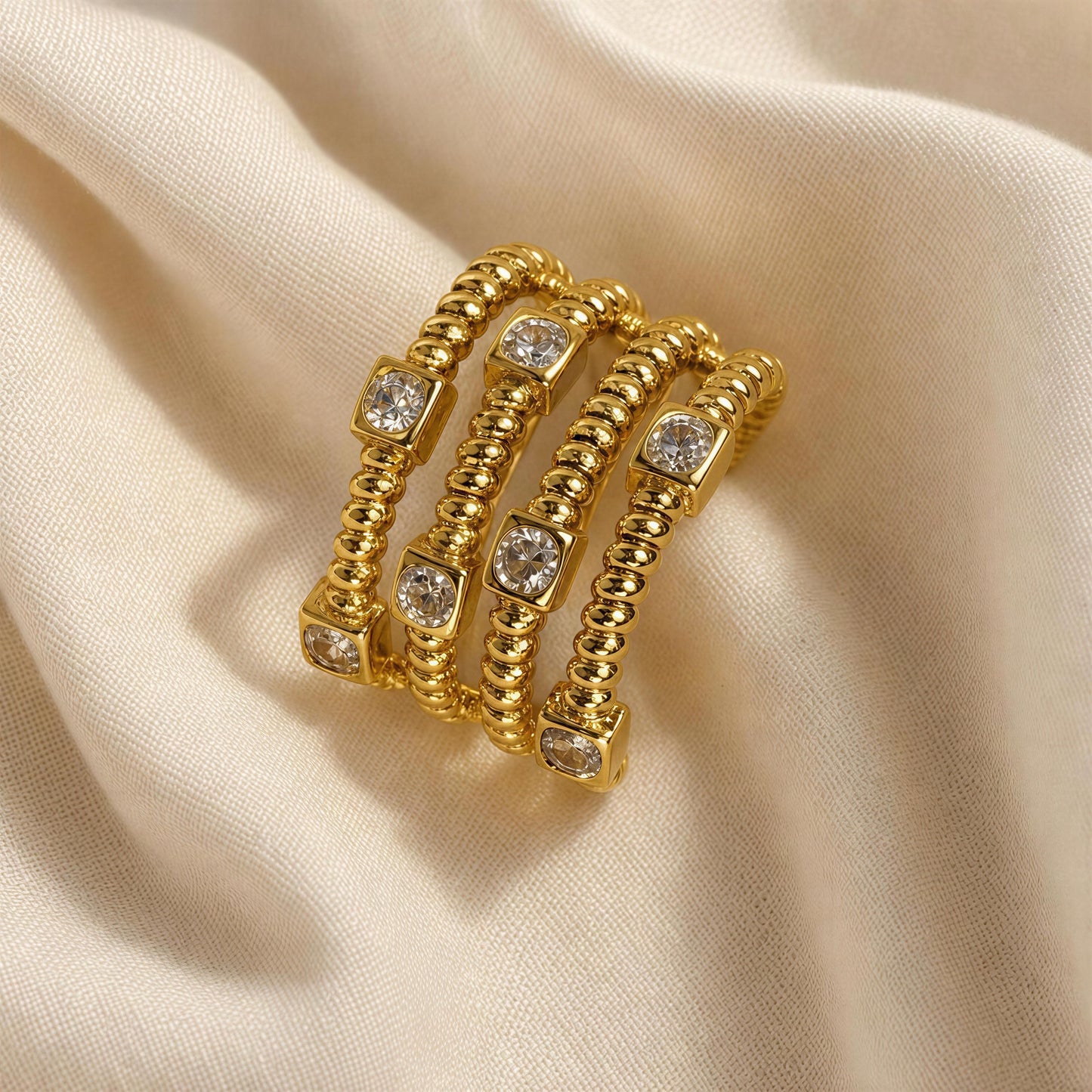 The Intreccio Ring from Chica Chica Jewelry against creme fabric