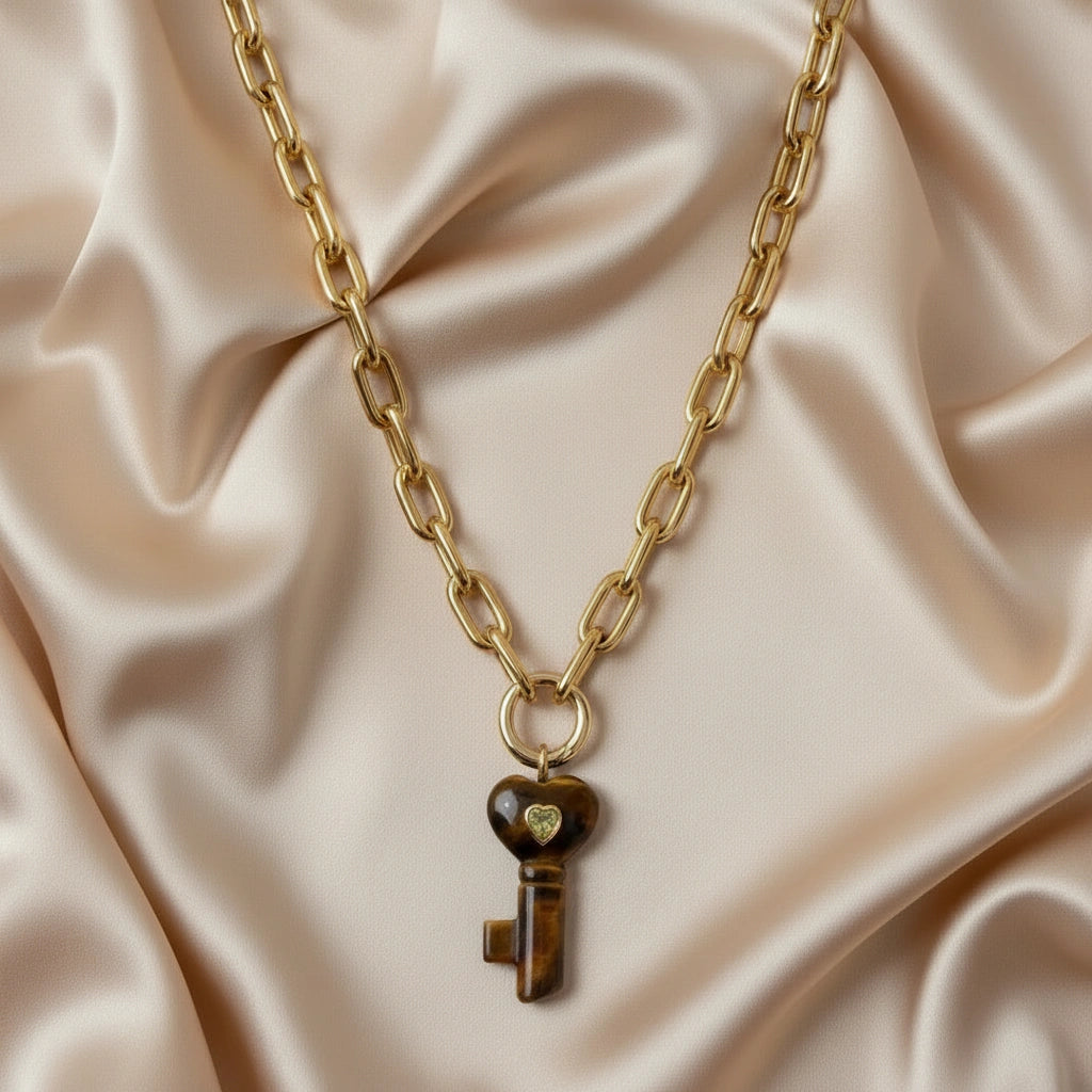 La Vita Forte – Tigre with a key-shaped pendant on a beige fabric background