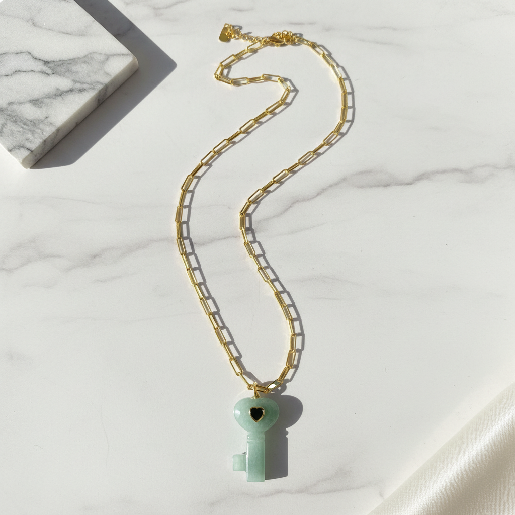 La Vita Key – Verde Necklace with a green key-shaped pendant on a marble surface
