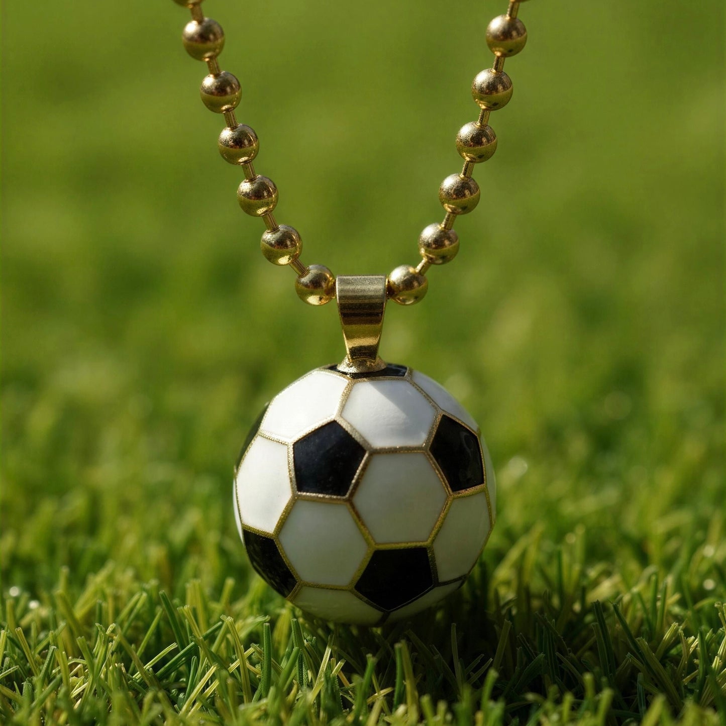 Soccer ball pendant on a chain lying on grass