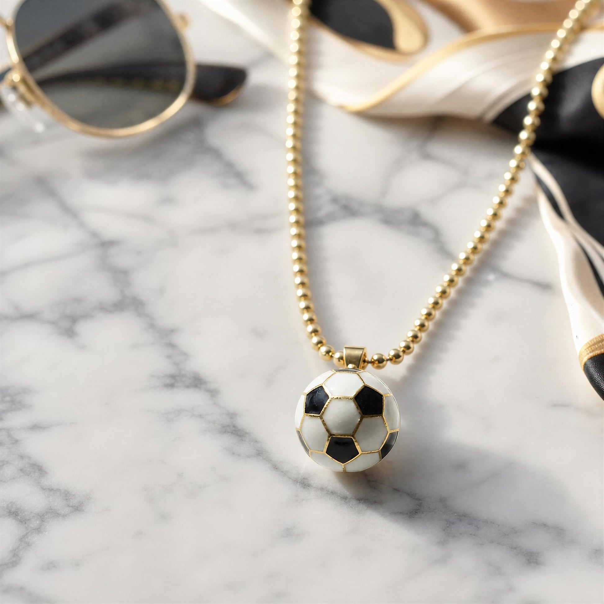 Necklace with a soccer ball pendant on a marble surface