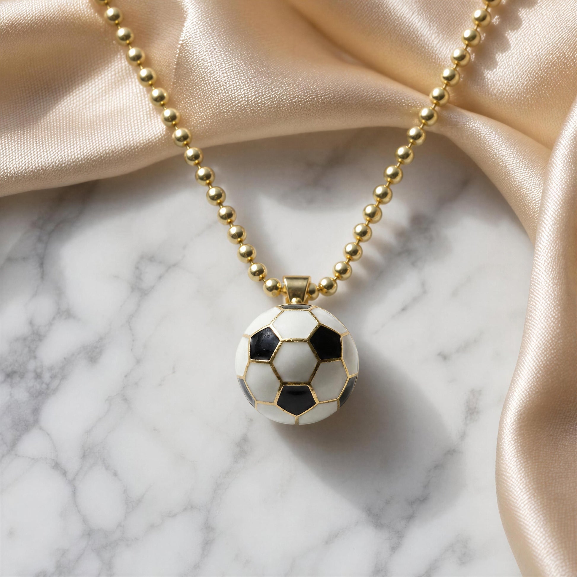 La Vittoria Charm Necklace with a soccer ball pendant on a marble surface