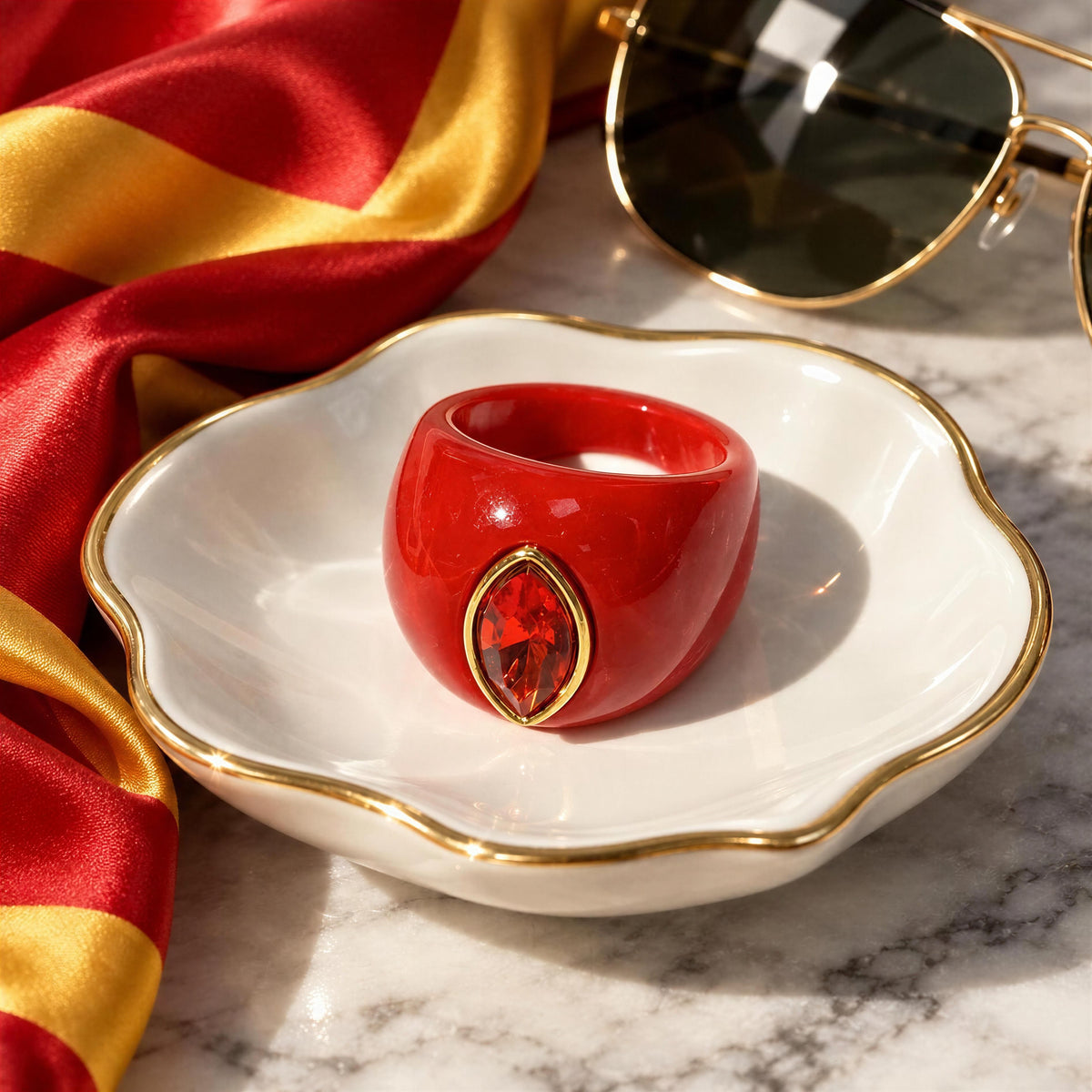 The Lola Ring — Tomato- Chica Chica Jewelry- Retro Glam Collection in a white and gold dish next to a red and yellow scarf and sunglasses.