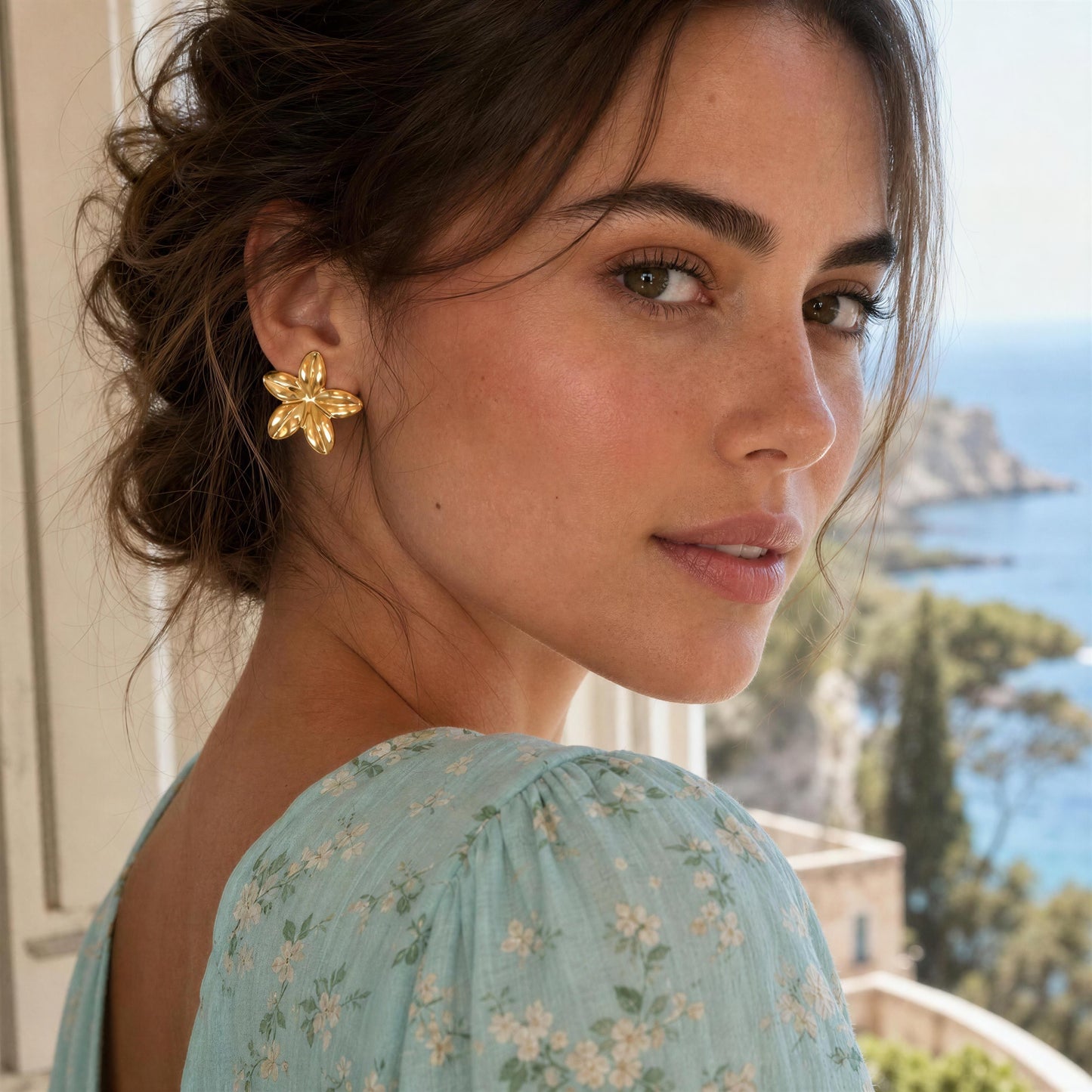 Woman wearing the Luna Bloom Earrings - Gold with a scenic background
