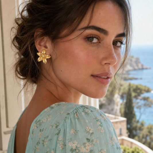 Woman wearing the Luna Bloom Earrings - Gold with a scenic background