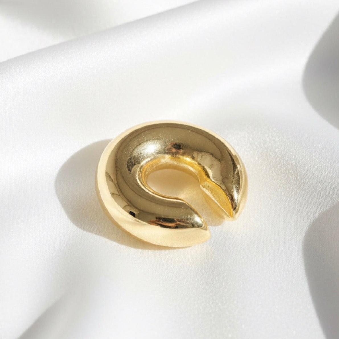 Lunar Arc Ear Cuff against a white fabric 