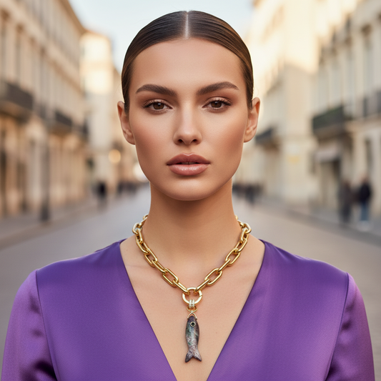 Model wearing Marea Fish Pendant Necklace in gold with natural gemstone fish charm and bold statement chain.