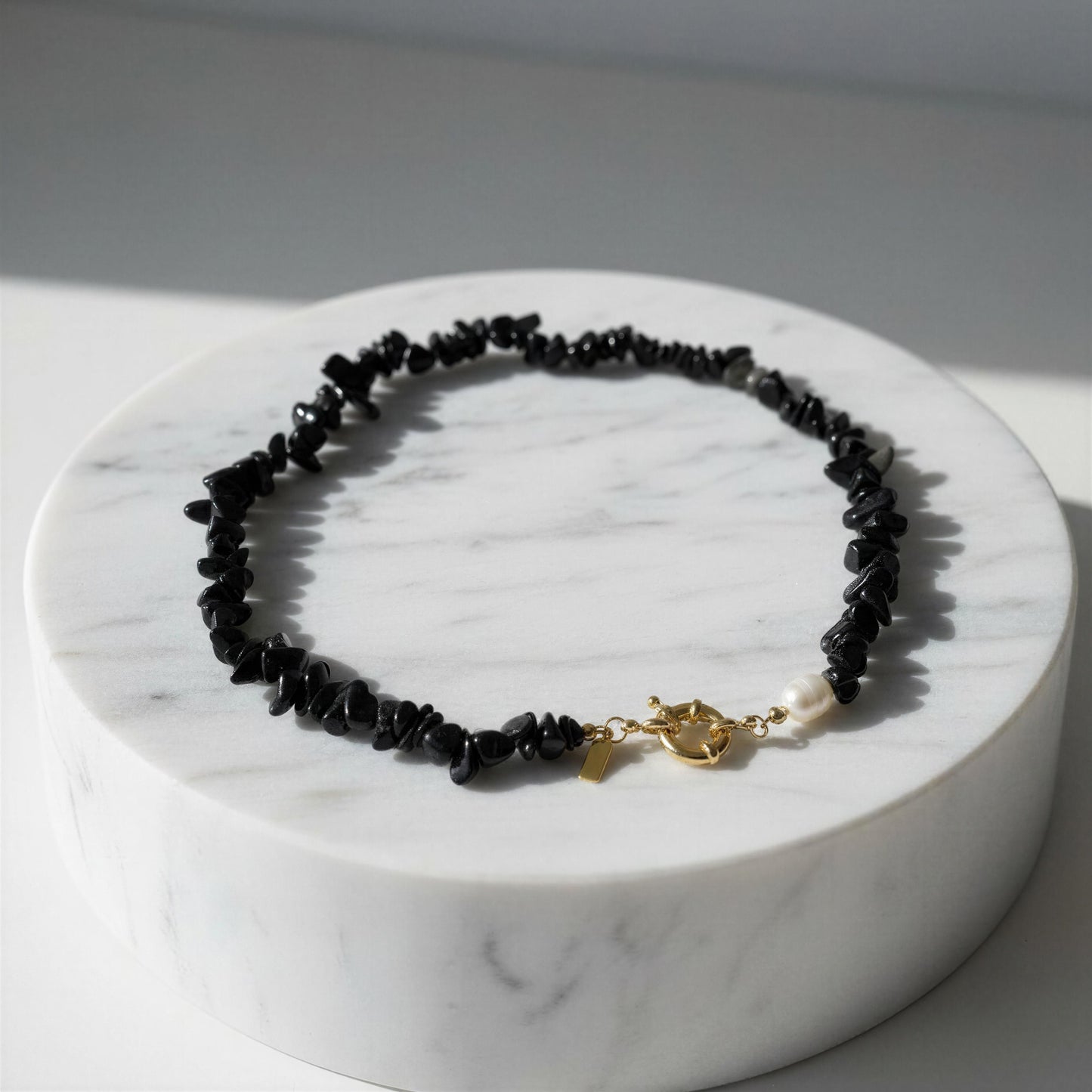Midnight Tide Necklace on a marble stand