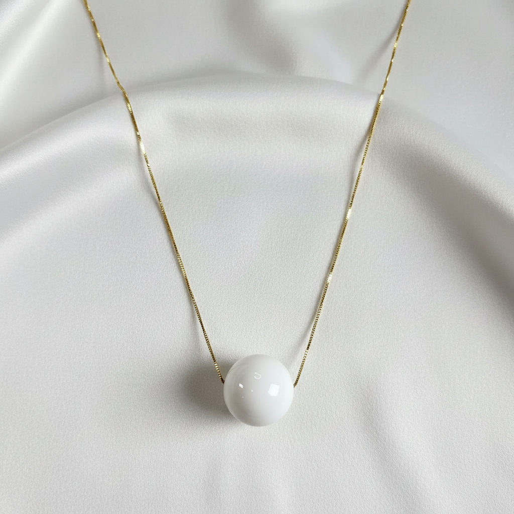 The Milky Bead Necklace on a white fabric background