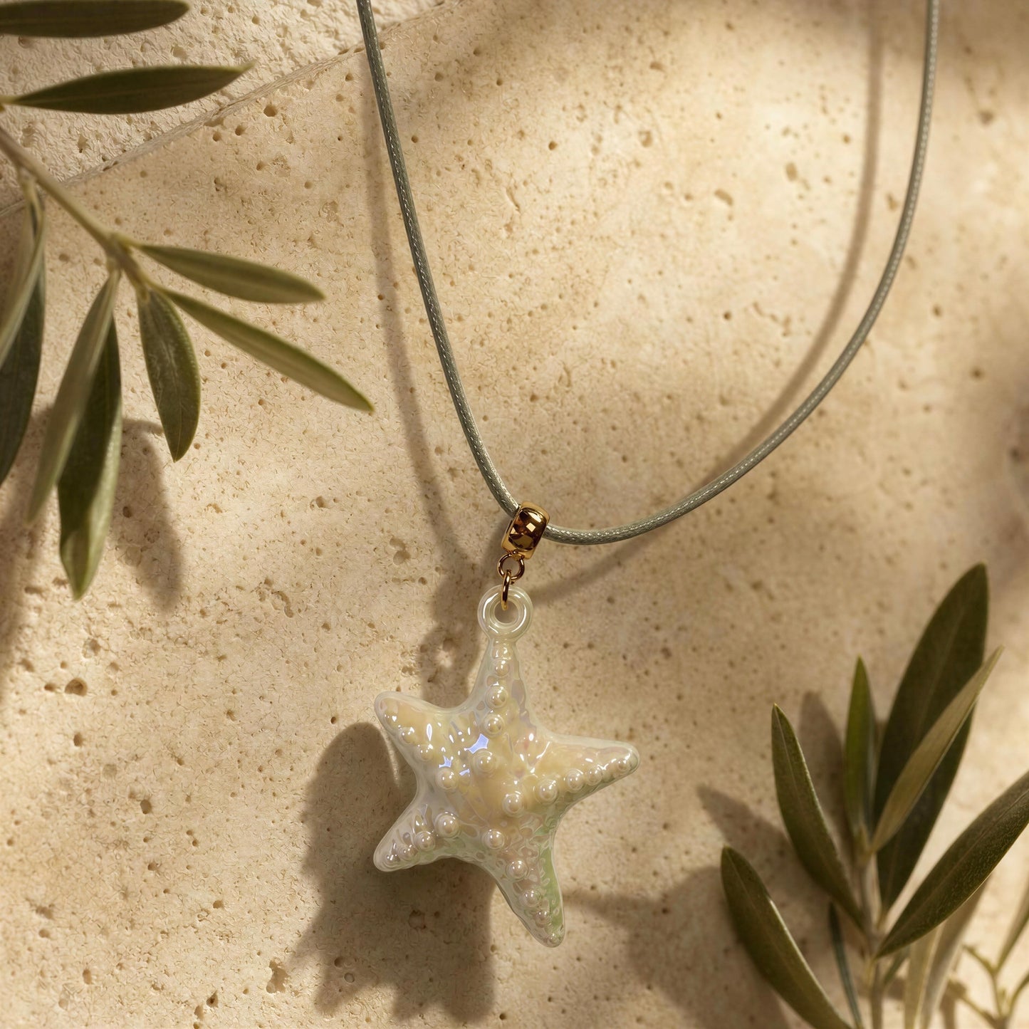 The Nerina Seafoam Starfish Necklace draped on travertine background.