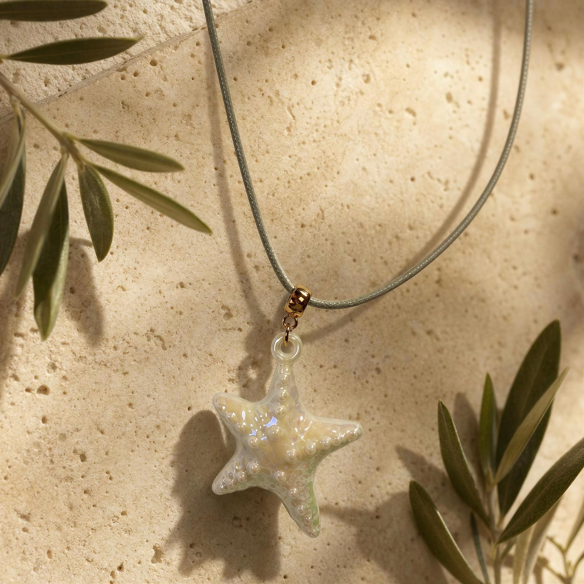 The Nerina Seafoam Starfish Necklace draped on travertine background.
