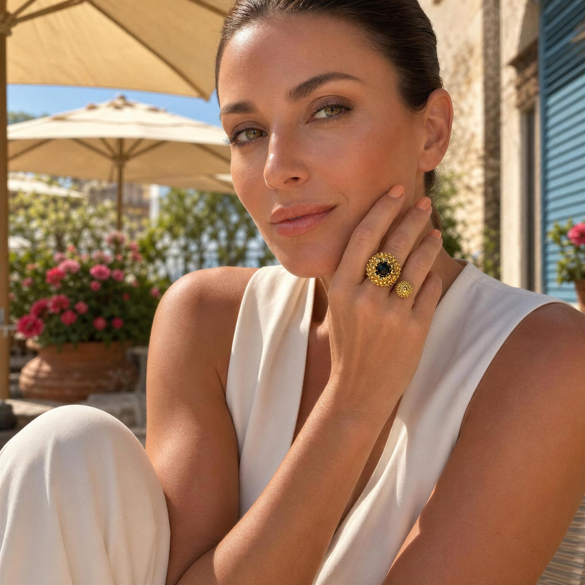A woman in a white sleeveless top poses outdoors wearing the Nero Ring from Chica Chica Jewelry  with a black center agate stone.