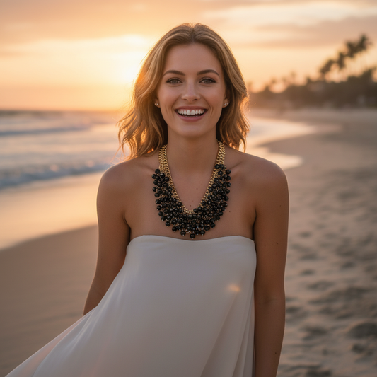 Woman in a white dress with a black necklace on a beach at sunset