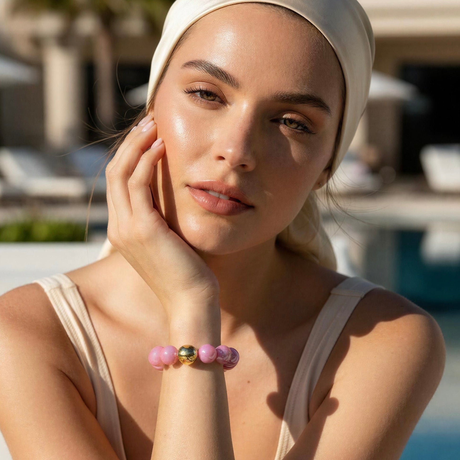 Woman wearing a headscarf and pink bracelet outdoors