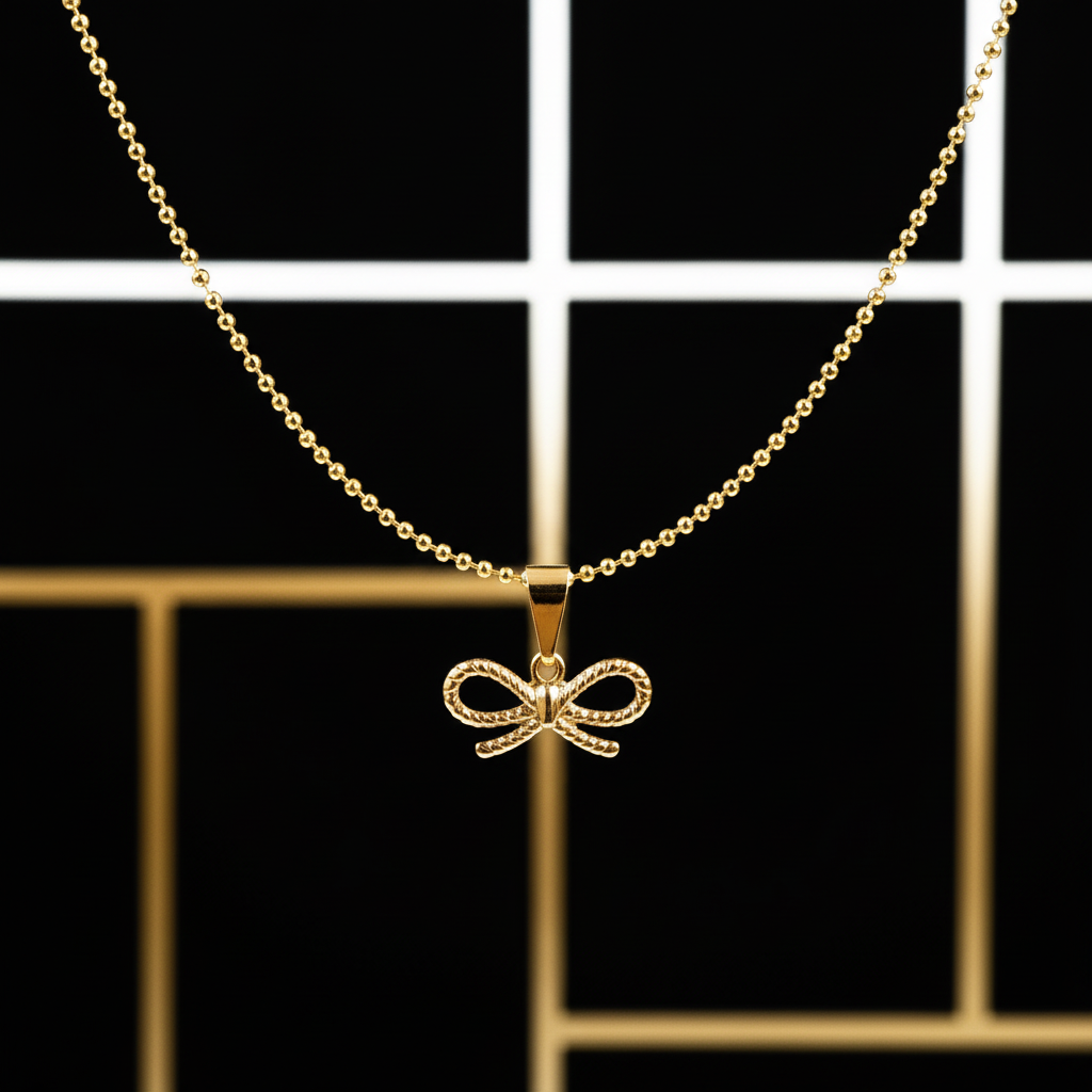 Gold Chica Chica Jewelry  necklace with a bow pendant on a black and gold checkered background