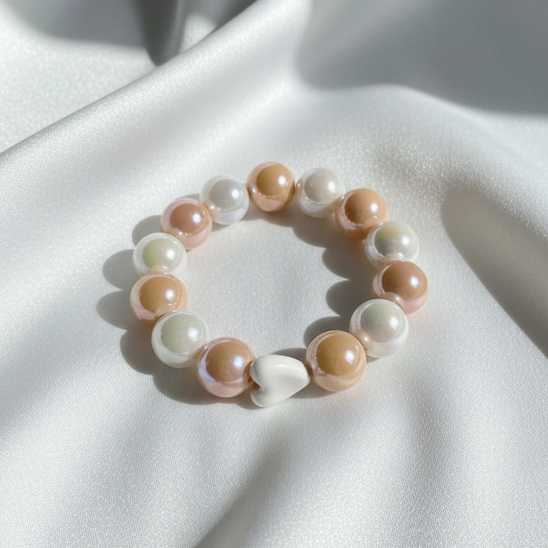 
Flat lay of the Powder Pink Amore Bracelet with opalescent powder pink beads arranged in a circular design
