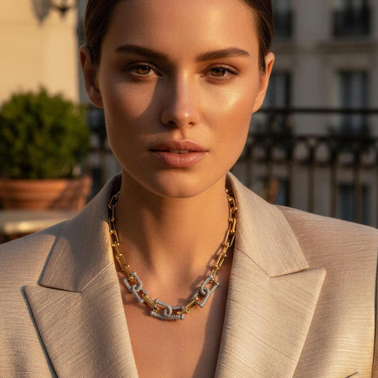 Woman wearing a beige blazer with a cityscape background wearing the Radiance Link Necklace.