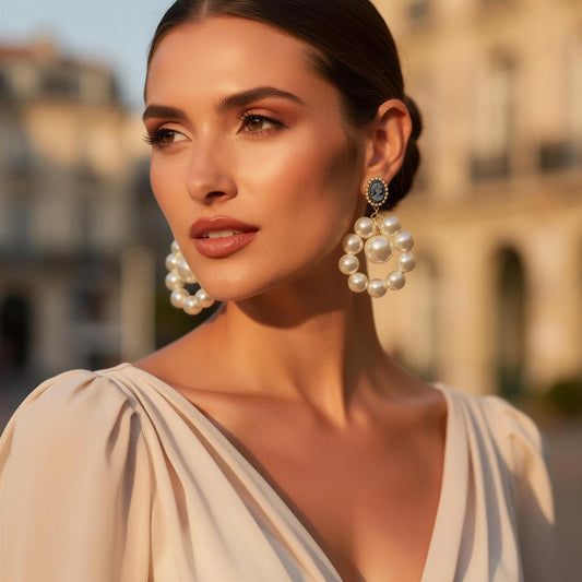 Woman wearing large pearl earrings with a blurred architectural background