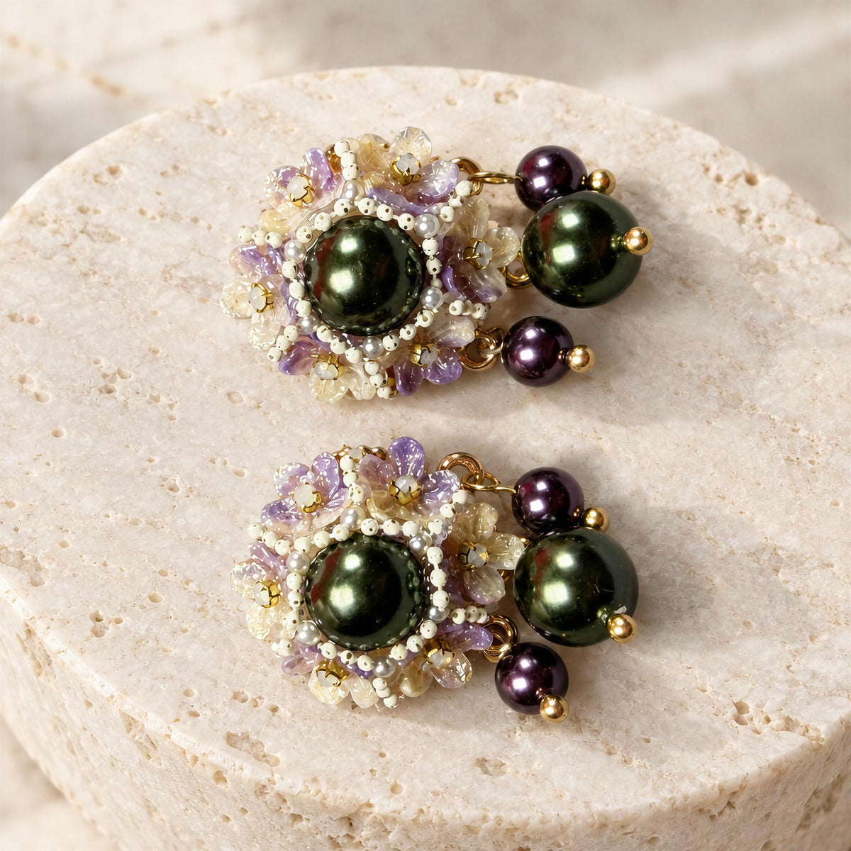 The Paloma Earrings from Chica Chica Jewelry agaisnt a crème color stone.