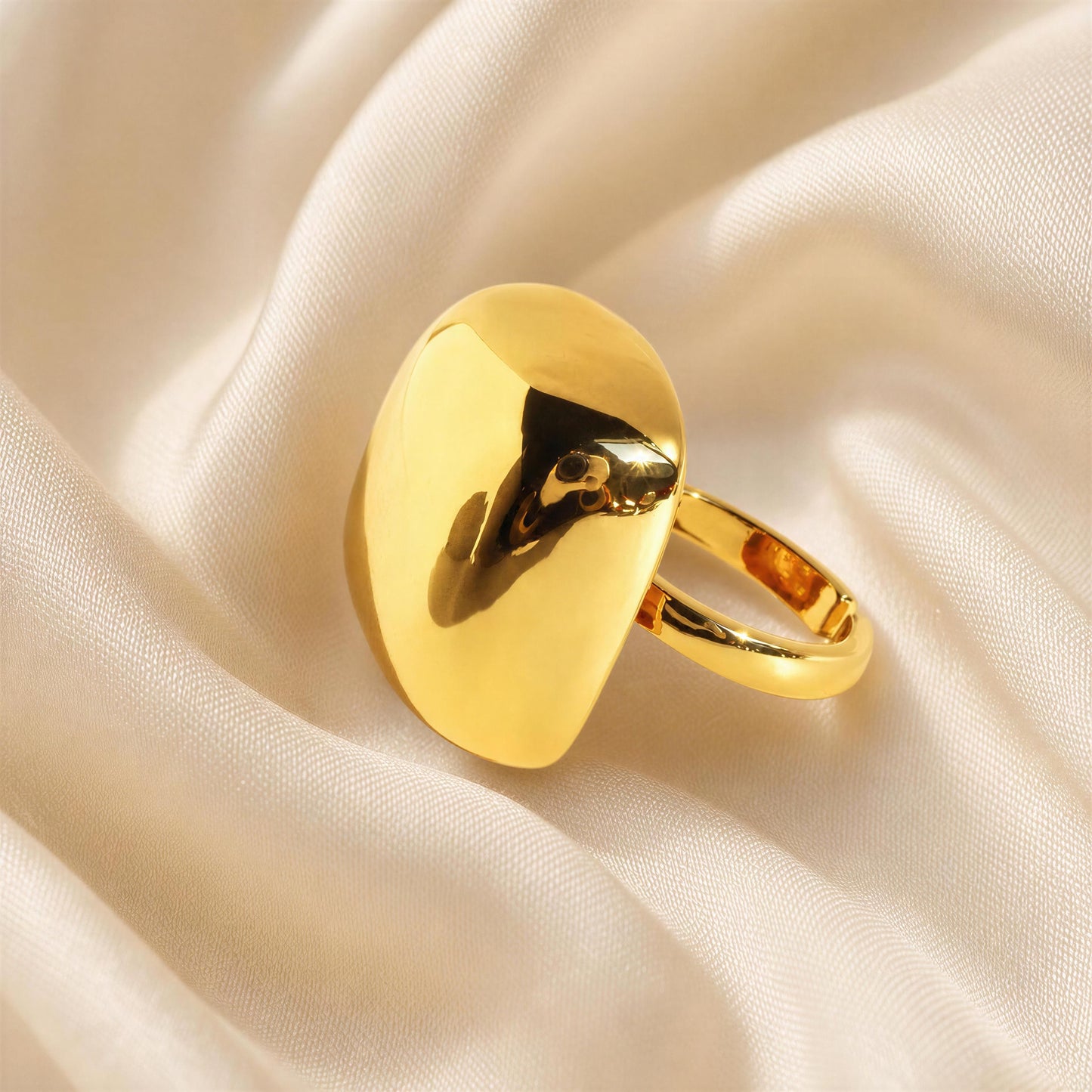 The Aurelia Ring from Chica Chica Jewelry , resting on draped cream-colored satin fabric.
