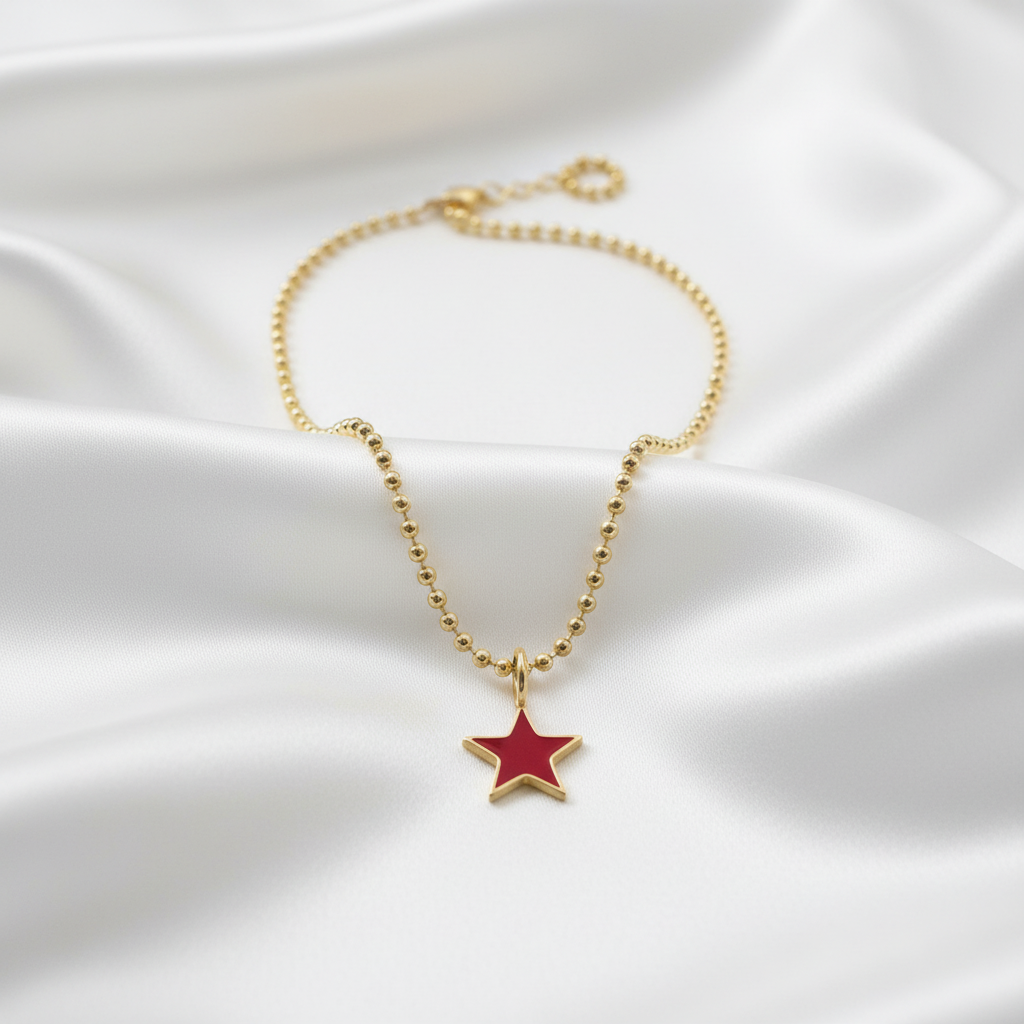 Scarlet Star Necklace with a red star pendant on a white fabric background