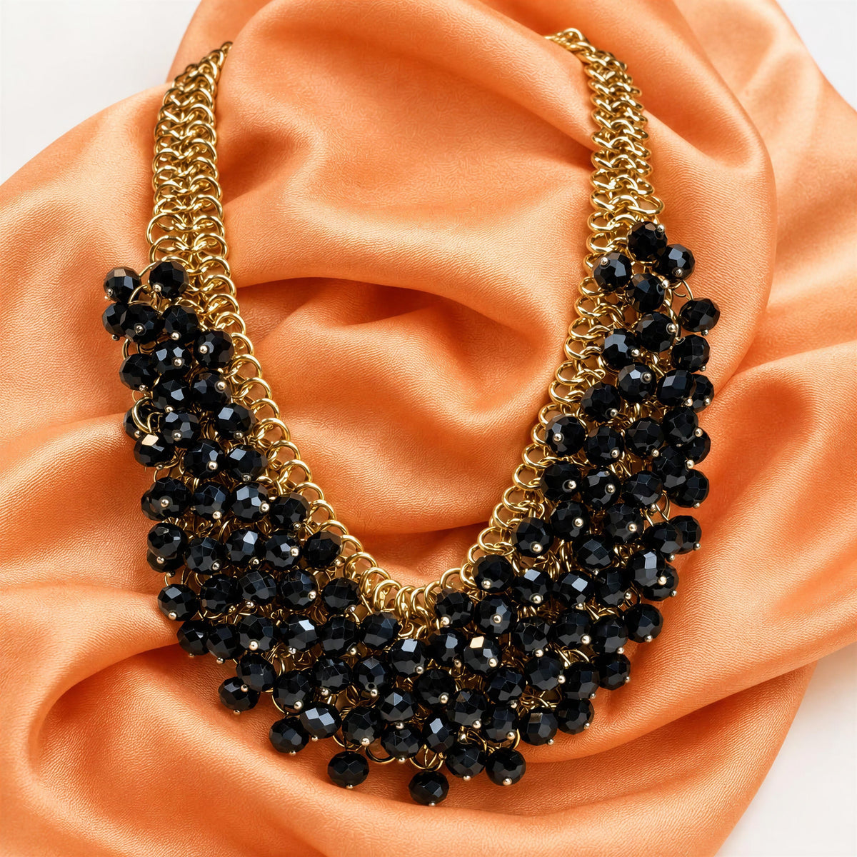 The Marcella Necklace from Chica Chica Jewelry against a melon color silk scarf.