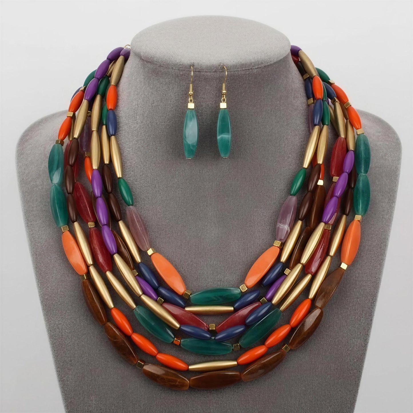 Colorful beaded necklace and earrings on a gray mannequin bust.