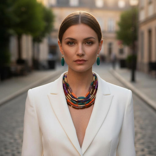 Woman wearing a the Riviera Mosaic Necklace Set and white blazer on a blurred street background