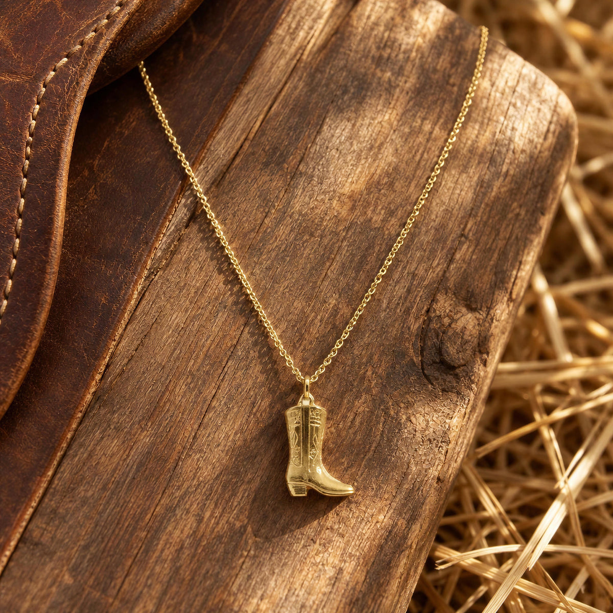 The Rodeo Necklace from Chica Chica Jewelry flatlay on wood at a horse stable. 