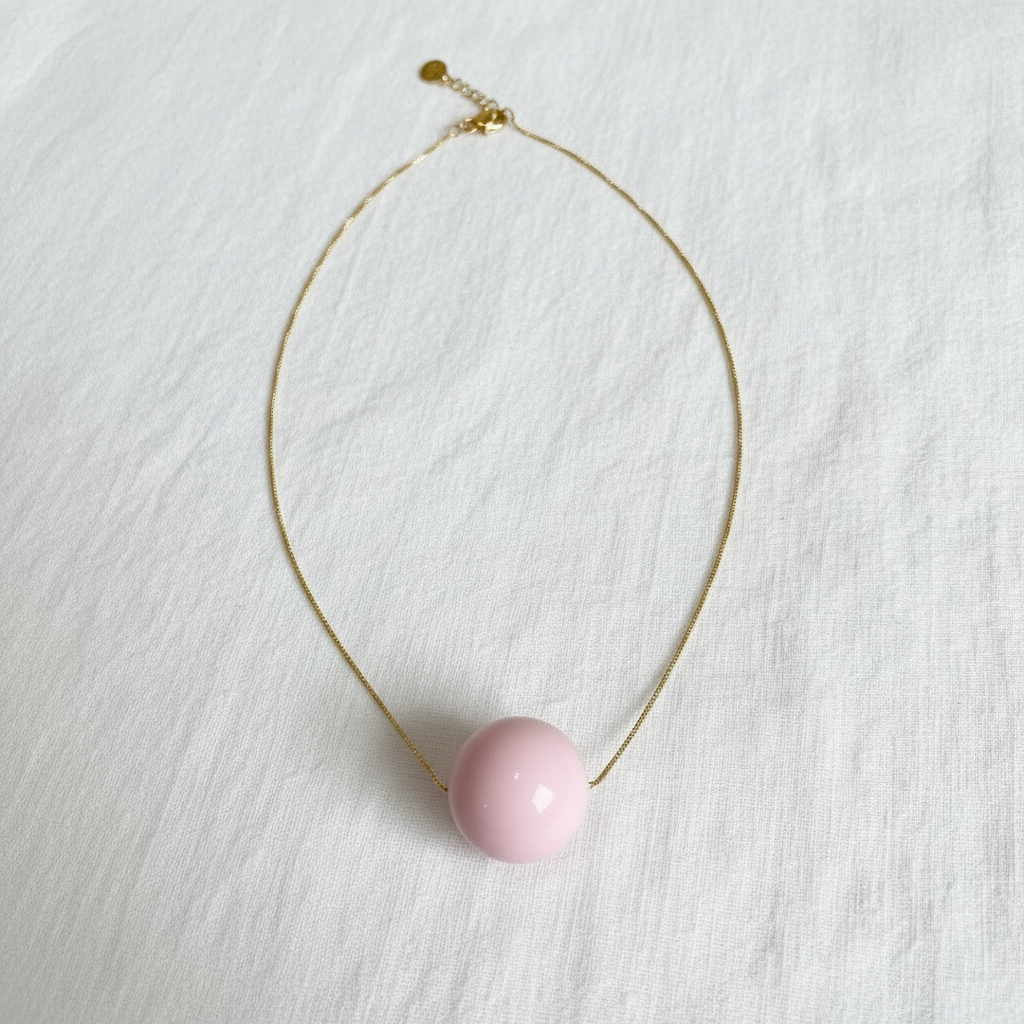 Necklace with a pink pendant on a white background
