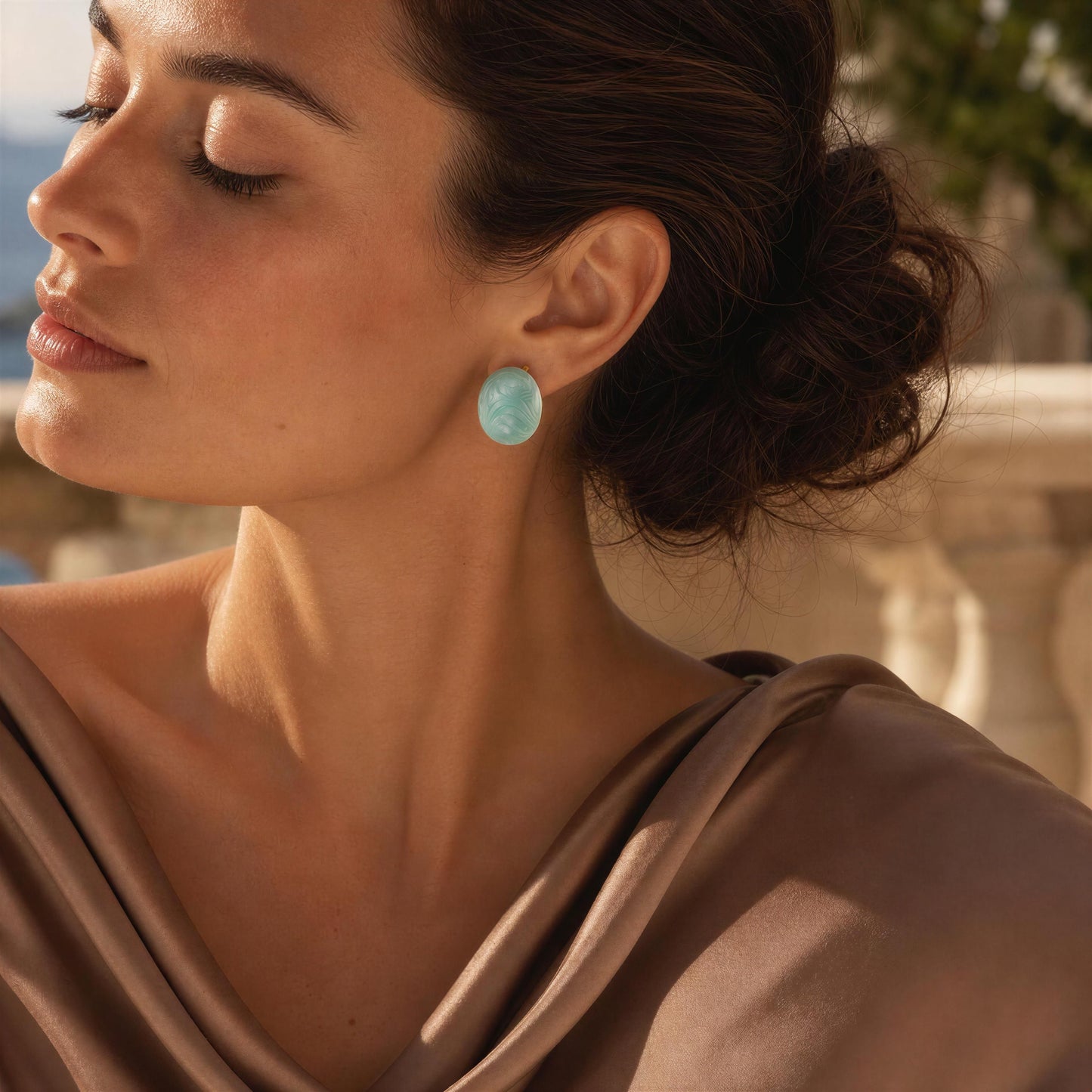 Woman wearing the Rosina Studs -Aqua Glow with a blurred outdoor background